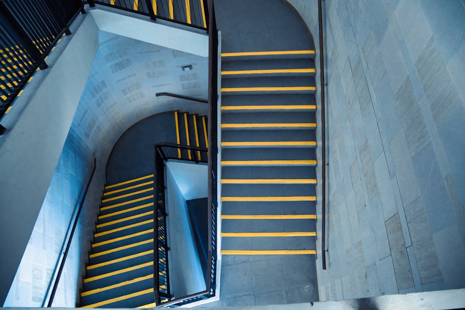 A narrow, worn staircase with blue-painted wooden steps, some of which have chipped paint revealing the wood beneath, leading to an upper floor in a residential property. Adjacent to the staircase on